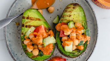 Grilled avocado halves with smoky harissa peanut butter